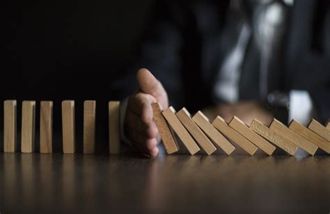 businessman stop domino effect risk management