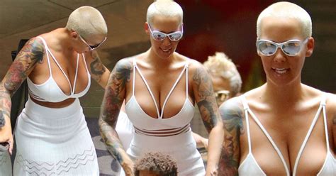 amber rose nearly bursts out of low cut white dress as she flaunts her