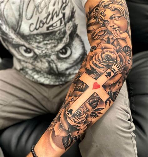 A Man With A Cross And Roses Tattoo On His Arm