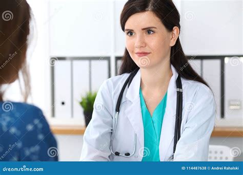 Beautiful Female Doctor Reassuring Her Patient While Sitting At The