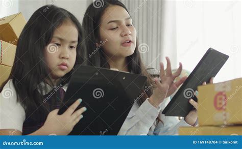 Asian Sisters And Sisters Use A Tablet Computer To Check The Products