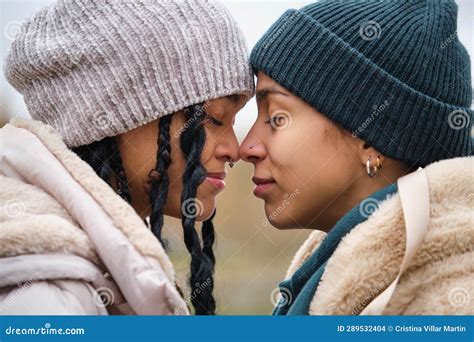 dominican lesbian couple showing affection and love at street in winter