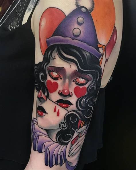 a woman s arm with an evil clown and heart balloon tattoo on her left arm