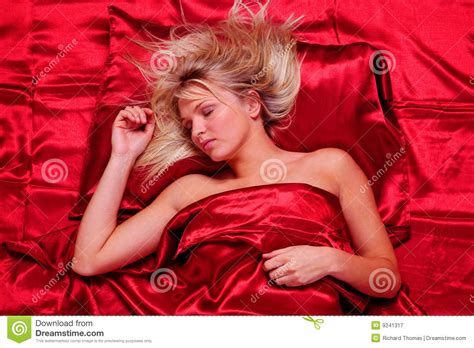 Blonde Woman Asleep On Red Satin Sheets Royalty Free Stock