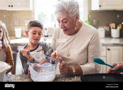 Grandson And Great Grandma Making Breakfast Pancakes In The Kitchen