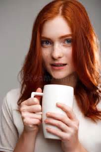 Portrait Of Beautiful Ginger Girl Holding Cup Over Gray Background