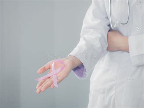 Pink Bow In A Doctor Hand Two Hands Holding Small Pink Symbol Cancer