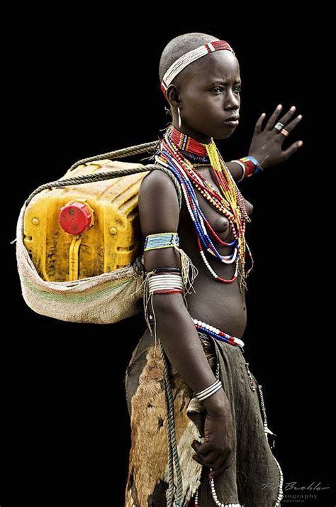 An African Woman Carrying A Yellow Bag On Her Back And Wearing Jewelry