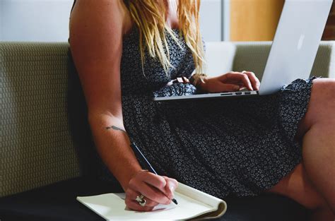 closeup photo of woman sitting in the sofa writing in the notebook hd