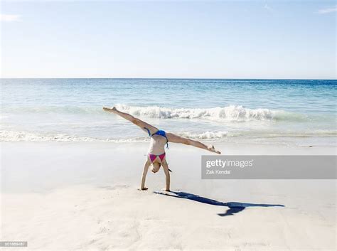 girl doing handstand and splits on beach photo getty images
