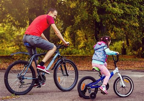 father with mother teaching their little son how to ride bicycle photo