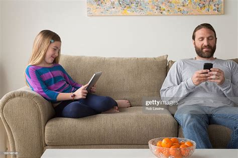 Father And Daughter Sitting On Couch Photo Getty Images