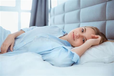 woman stretching in bed after wake up entering a day happy and relaxed after good night sleep