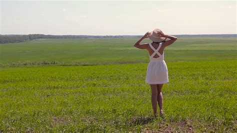 beautiful girl with a naked torso dancing on a green field back view stock footage video