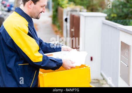 postman delivering letters  mailbox   recipient stock photo alamy