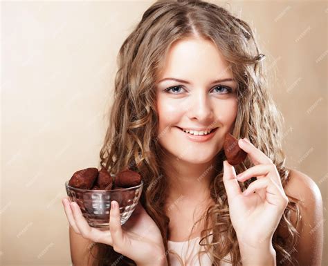 Premium Photo Beautiful Woman Eating A Chocolate Bonbon