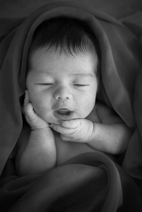 newborn photography singapore baby wrapped   smiling portrait