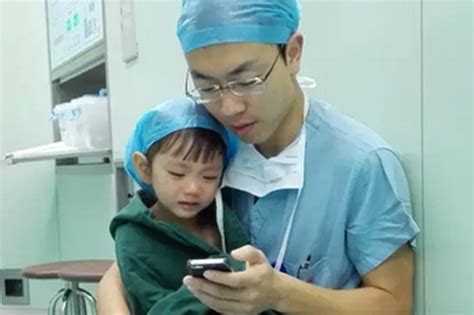 heart surgeon comforts crying girl in operating theatre by playing cartoons on his phone world