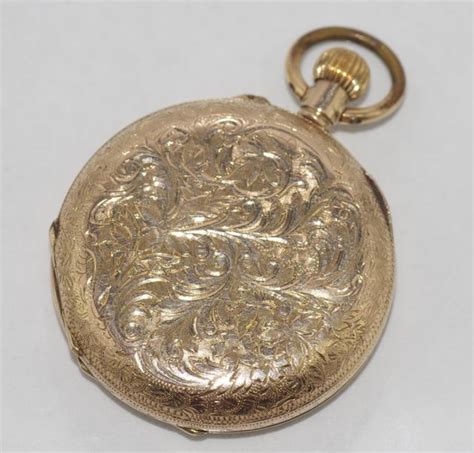 ladies gold pocket watch with engraved case white enamel dial