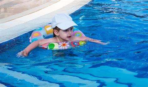 uśmiechnięta mała dziewczynka pływa w basenie zdjęcie stock obraz