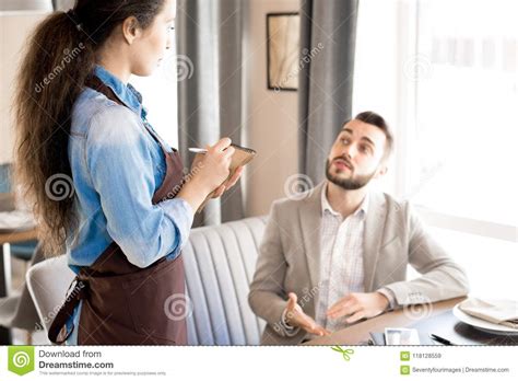 man sharing his taste preference with waitress stock image