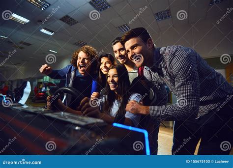 group  friends playing arcade machine stock image image  park