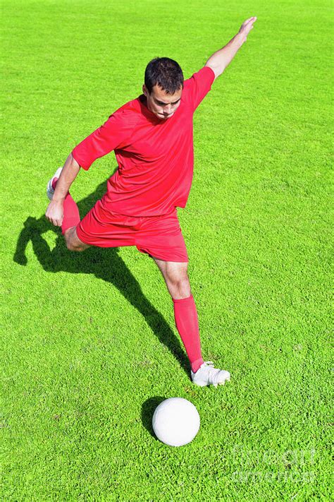 soccer player kicking ball photograph  microgen imagesscience photo