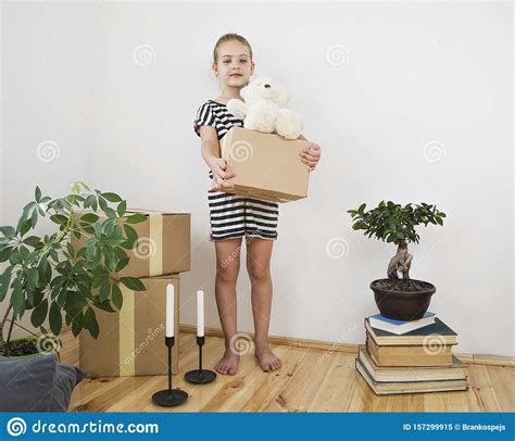 cute girl carrying boxes to new home on moving day stock