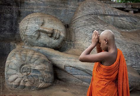 buddhist monk praying   reclining buddha polonnaruwa sri lanka
