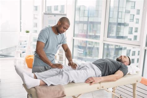 Massage Médical Bel Homme Intelligent Debout Près De Son Patient Tout