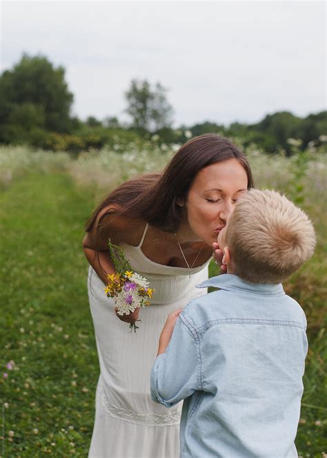 View Mother Kisses Son After He Gives Her A Bouquet Of Wildflowers By