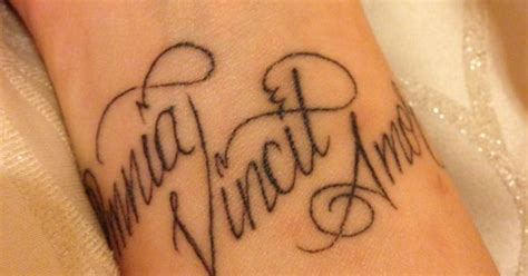 omnia vincit amor wrist tattoo love conquers all in