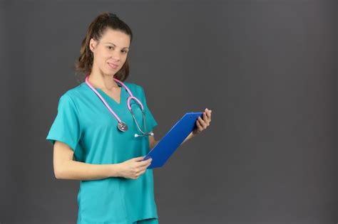 premium photo smiling brunette nurse holding with a pink stethoscope