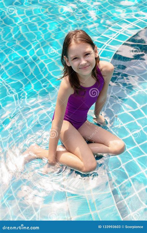 cute smiling preteen girl sitting at swimming pool edge travel