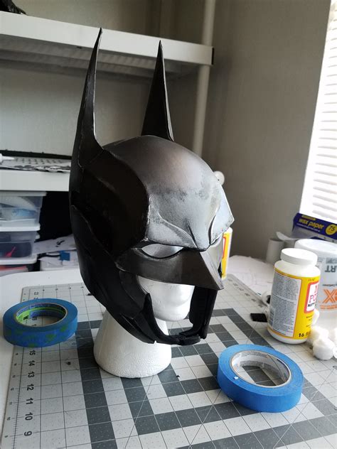 batman mask sitting  top   table    tape   items