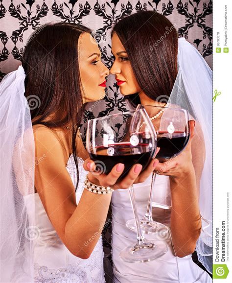 lesbian couples in wedding bridal dress kissing and drinking red wine stock image image of