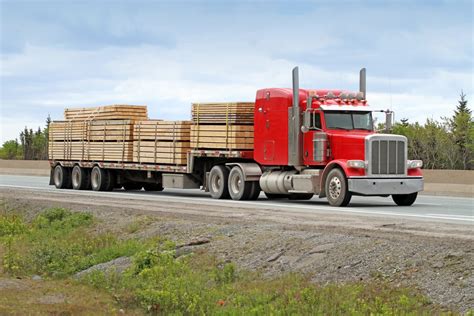 semi flatbed truck hauling  load  lumber   construction site