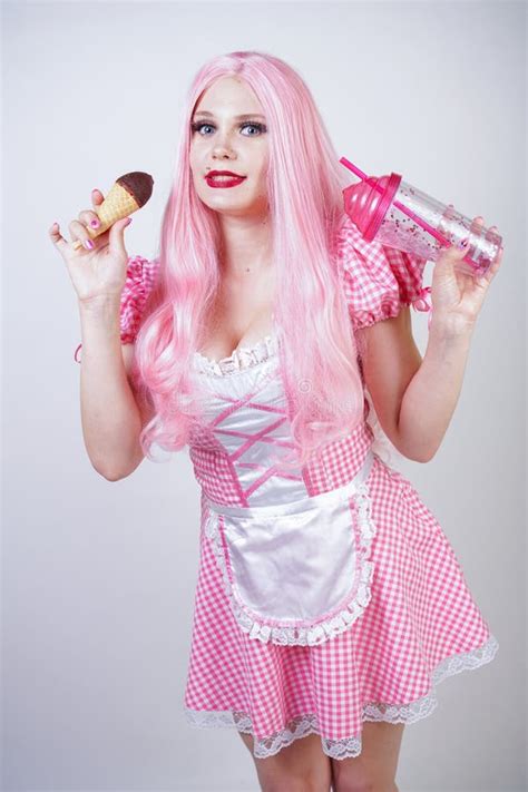 erotic caucasian chubby girl in pink plaid doll dress holds delicious