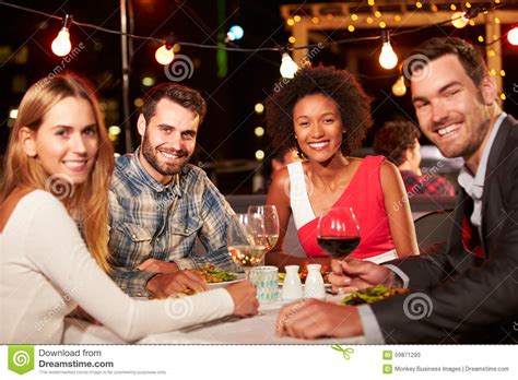 vier vrienden die diner eten bij dakrestaurant stock afbeelding image  viering datering