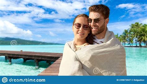 Happy Couple Covered With Blanket Hugging On Beach Stock Image Image