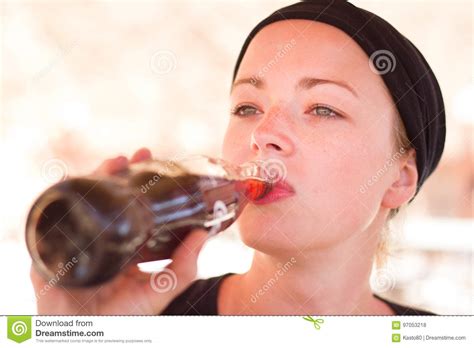 thirsty active female traveler drinking cola soft dring  glass bottle stock photo image