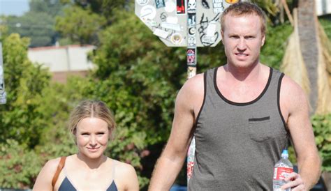 kristen bell holds hands with a male pal after a workout