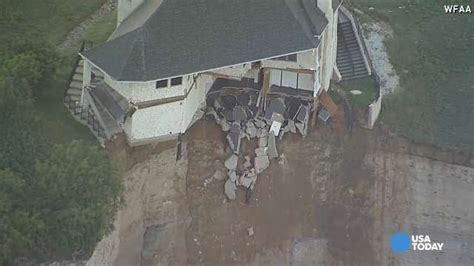 Couple Looks On As House Falls Off Cliff
