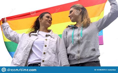 Happy Female Couple Raising Rainbow Flag March For Lgbt