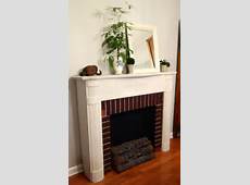 antique handmade faux fireplace . electric lit logs