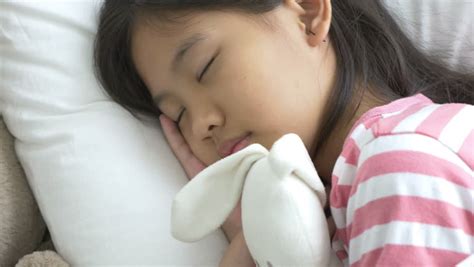 4k beautiful asian girl sleeping in bed opening eyes and smiling at camera dan stock footage