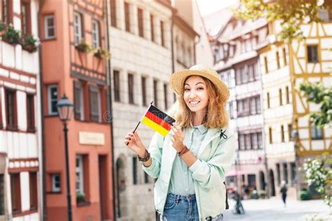 Asian Woman Tourist Traveling With German Flag Near The Famous Half