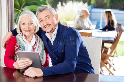 smiling grandmother and granddaughter using tablet stock