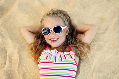 Top View Of Pretty Little Blonde Girl In Sunglasses Lying On Sandy