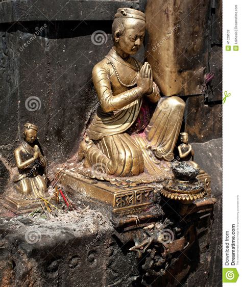 golden sculpture of praying man at swayambhunath stupa